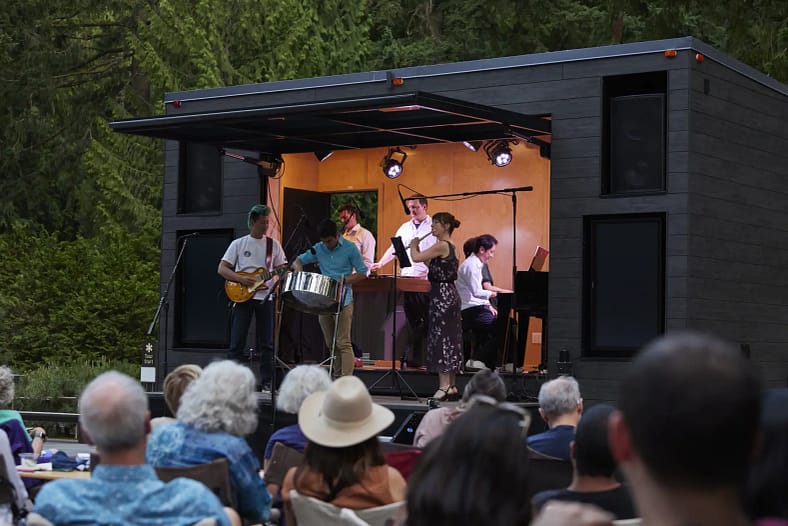 Musicians performing in a special custom-built mobile trailer that has a stage. 